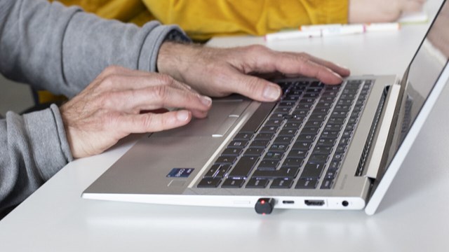 Person writing on a laptop keyboard.