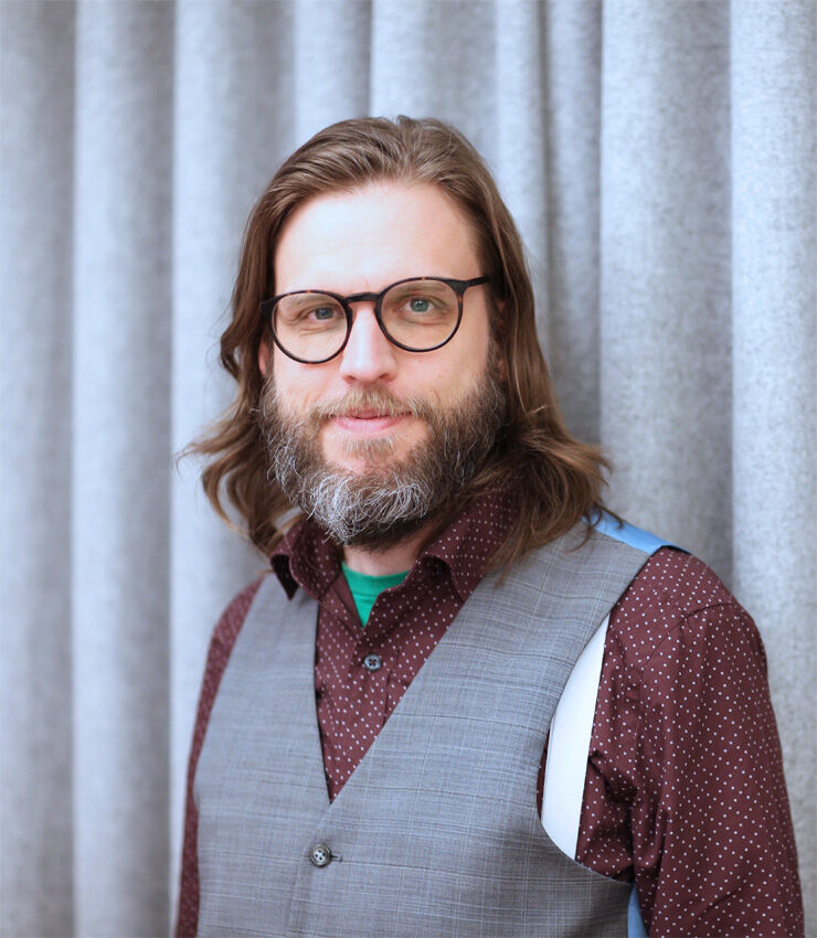 Inomhusporträtt av Johan Boström klädd i brun skjorta och grå väst. 