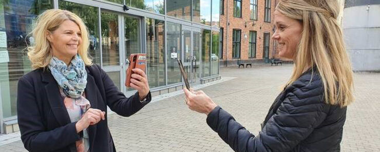 Two women looking at their mobilphones.