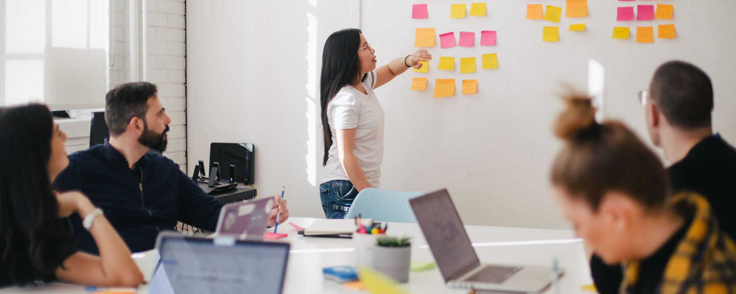 A woman standing in front of a whiteboard. 