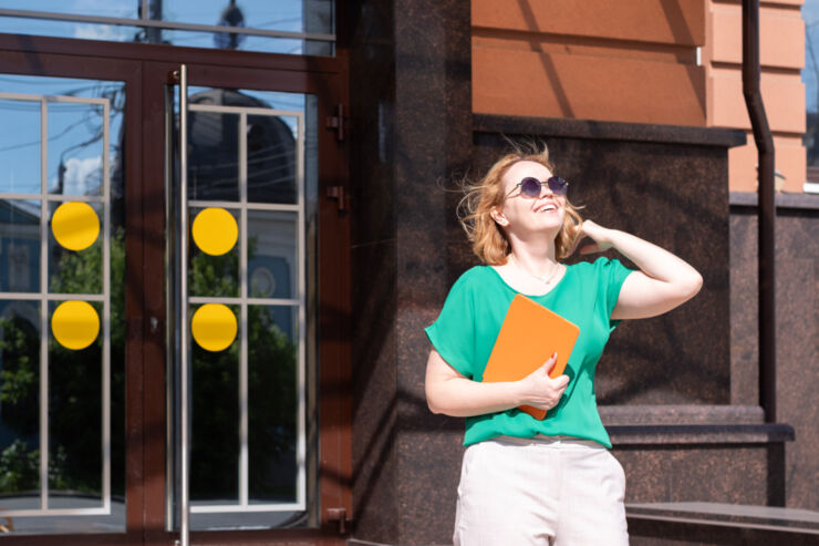 Female student with a tablet leaving a building