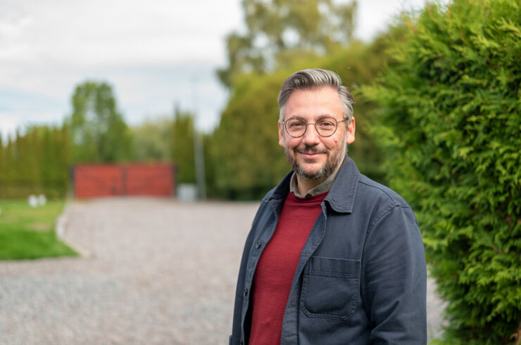 A person stands outside and peers into the camera. 