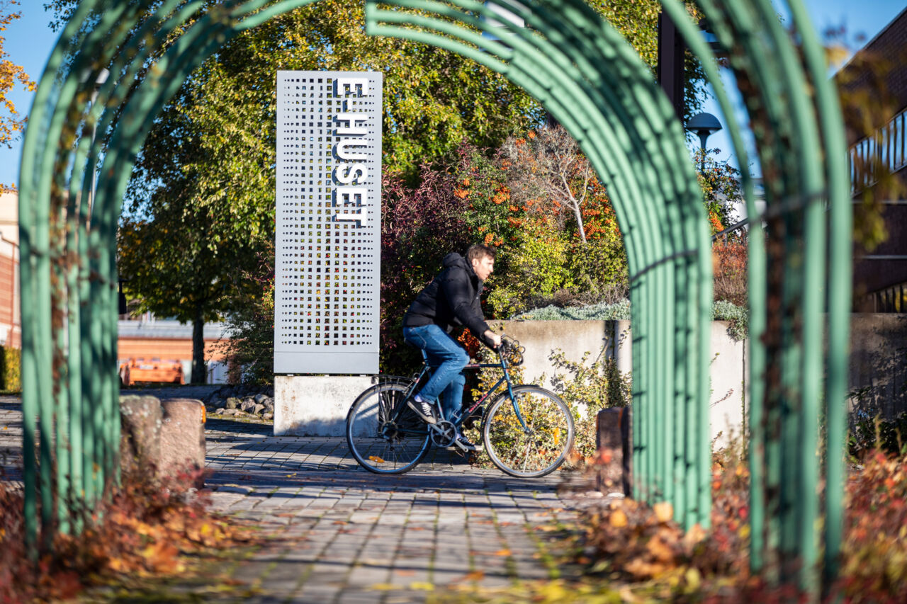 Autumn image with sign for E-building and cyclist