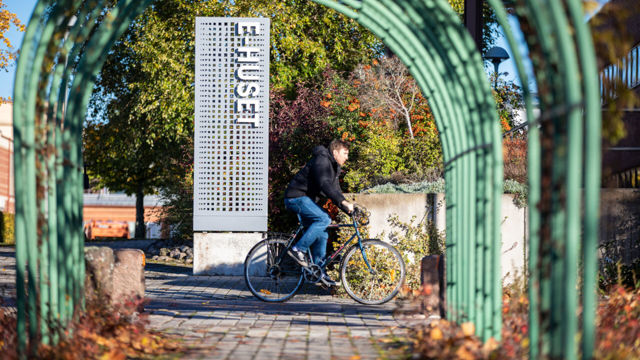Autumn image with sign for E-building and cyclist