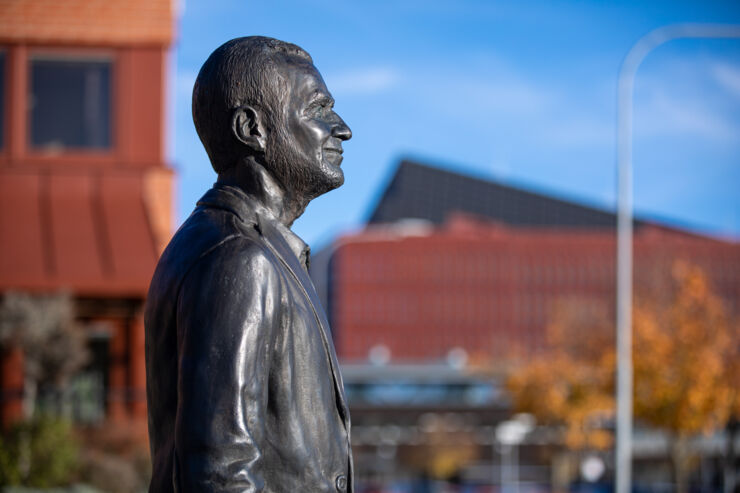 Staty på Erik Sandewall med byggnader i bakgrunden
