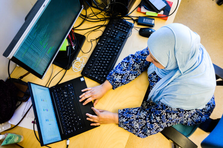 Female researcher by a computer, seen from above.