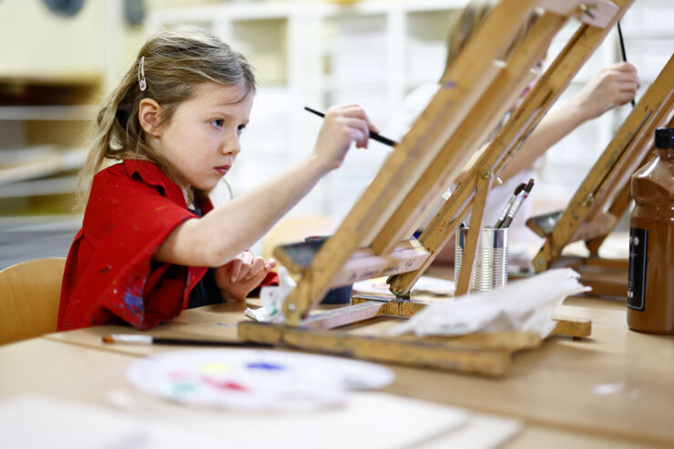 A child is painting with oil paint.