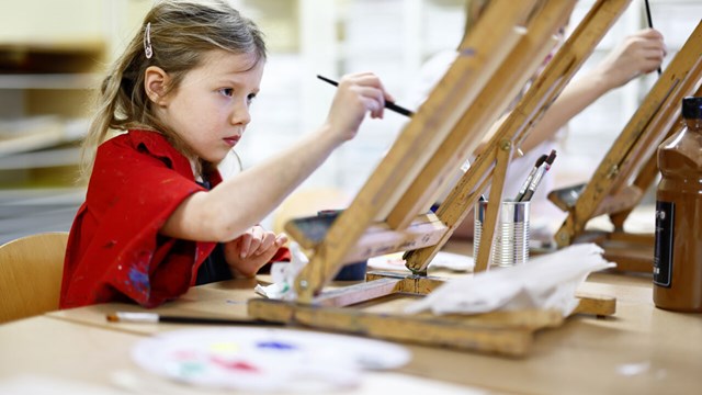 A child is painting with oil paint.
