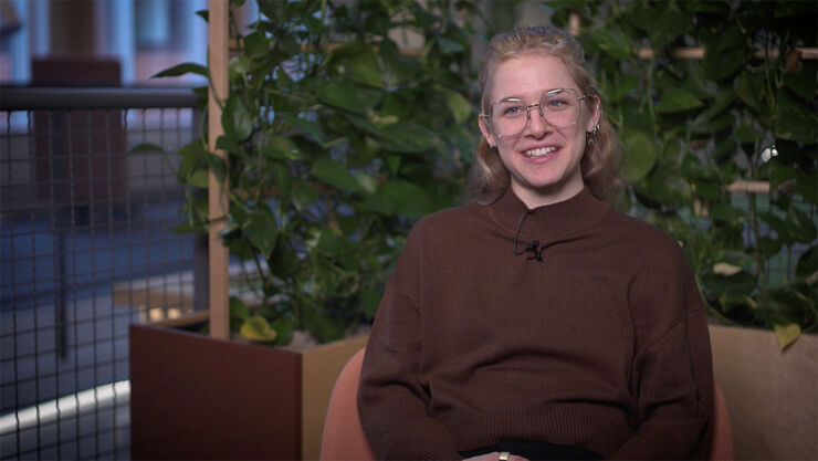 Smiling young woman in brown sweater and big glasses