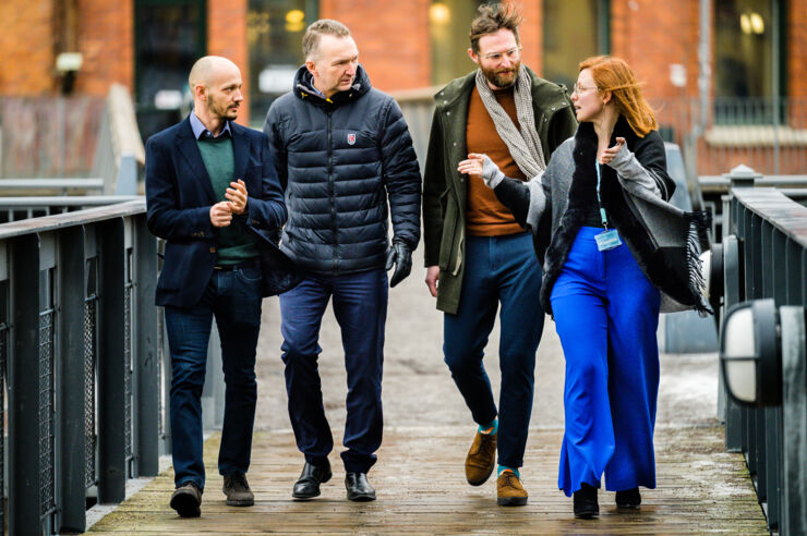 Four persons walking next to each other.