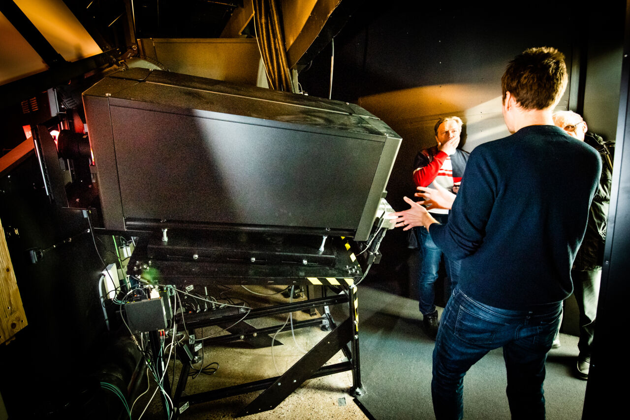 Tre personer står i maskinrummet för Domen på Visualiseringscenter C.