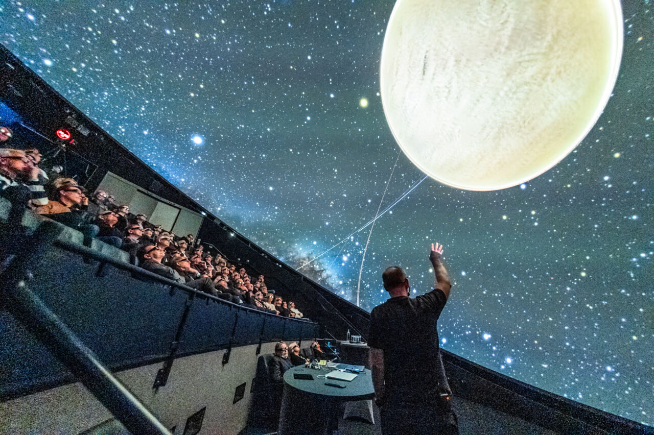 En föreläsare visar bild på en himlakropp i Domen vid Visualiseringscenter C.