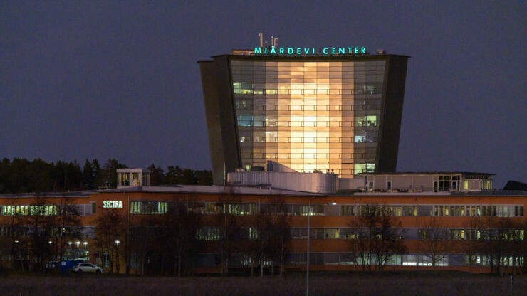 Tall, illuminated building in darkness. Sign 