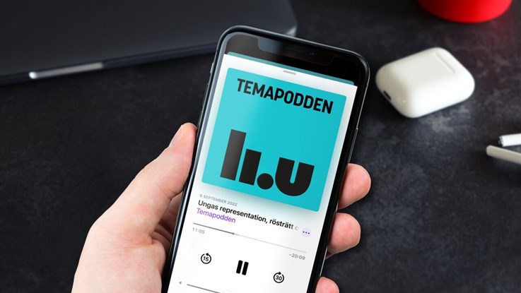 Hand som håller upp mobiltelefon är podcasten Temapodden visas.