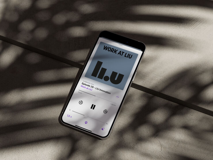 Smartphone lies on a stone floor and showing the podcast Work at LiU on the screen.