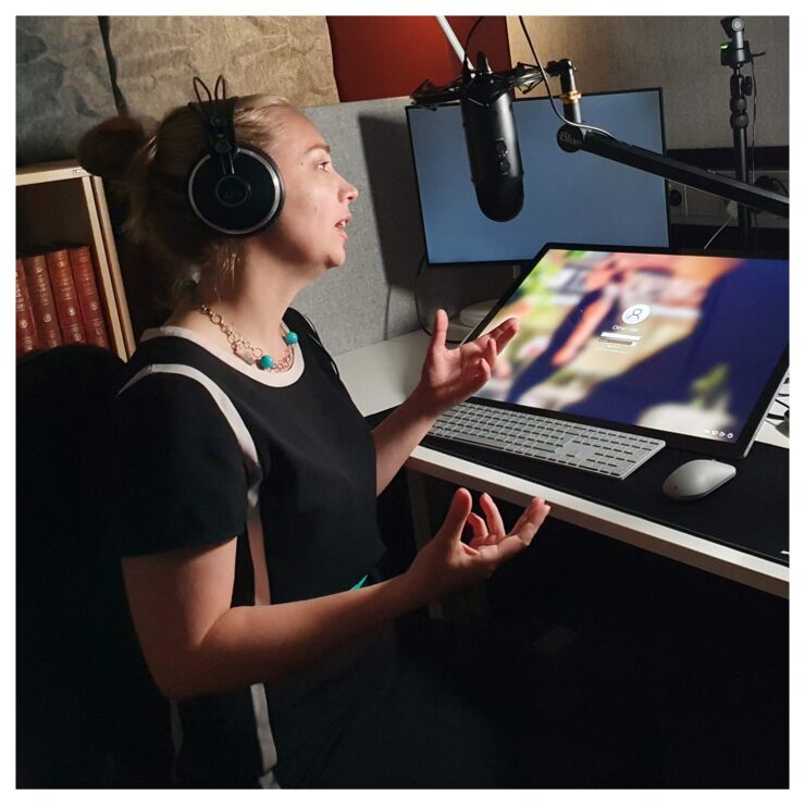 The host Helena Iacobaeus sitting in a studio talking into the mic.