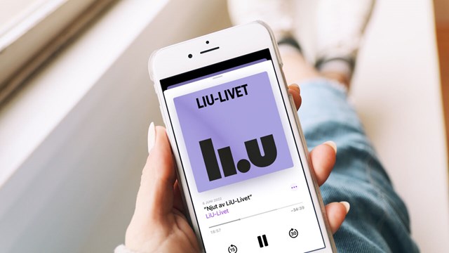 Person sitter i ett fönster och håller upp mobiltelefon som visar podcasten LiU-Livet på skärmen.