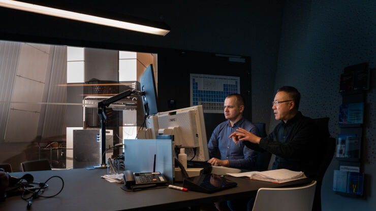 Two researchers infront of a computer in a dark room.