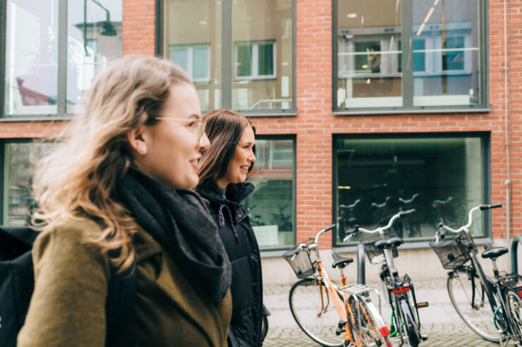 Två personer går bredvid varandra utomhus. 