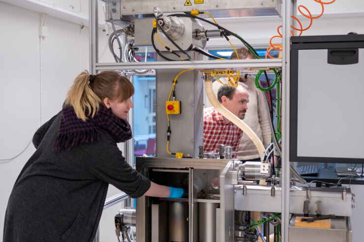 Forskare samtalar i rummet med 3D skrivare.