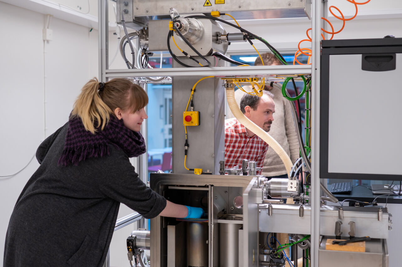 Forskare samtalar i rummet med 3D skrivare.