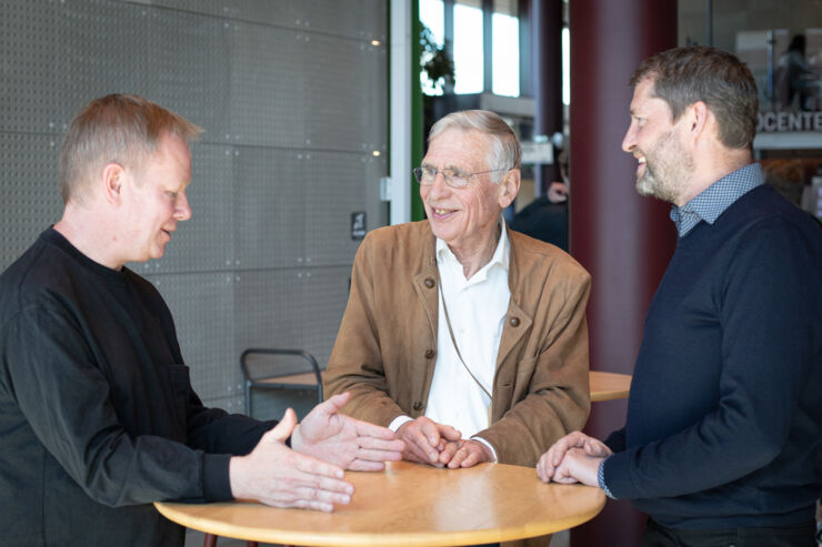 Three persons around a table.