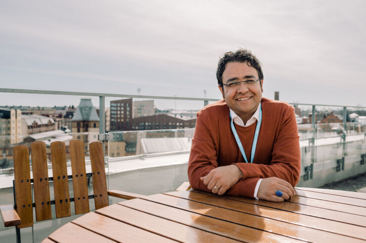 Man on roof terrace with city view.