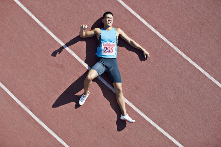 Injured athlete on running track.