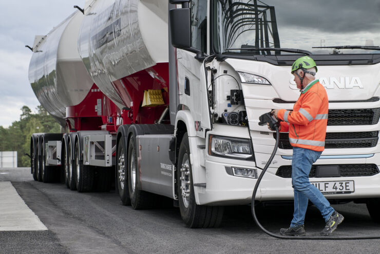 A man is charging an electrical truck.