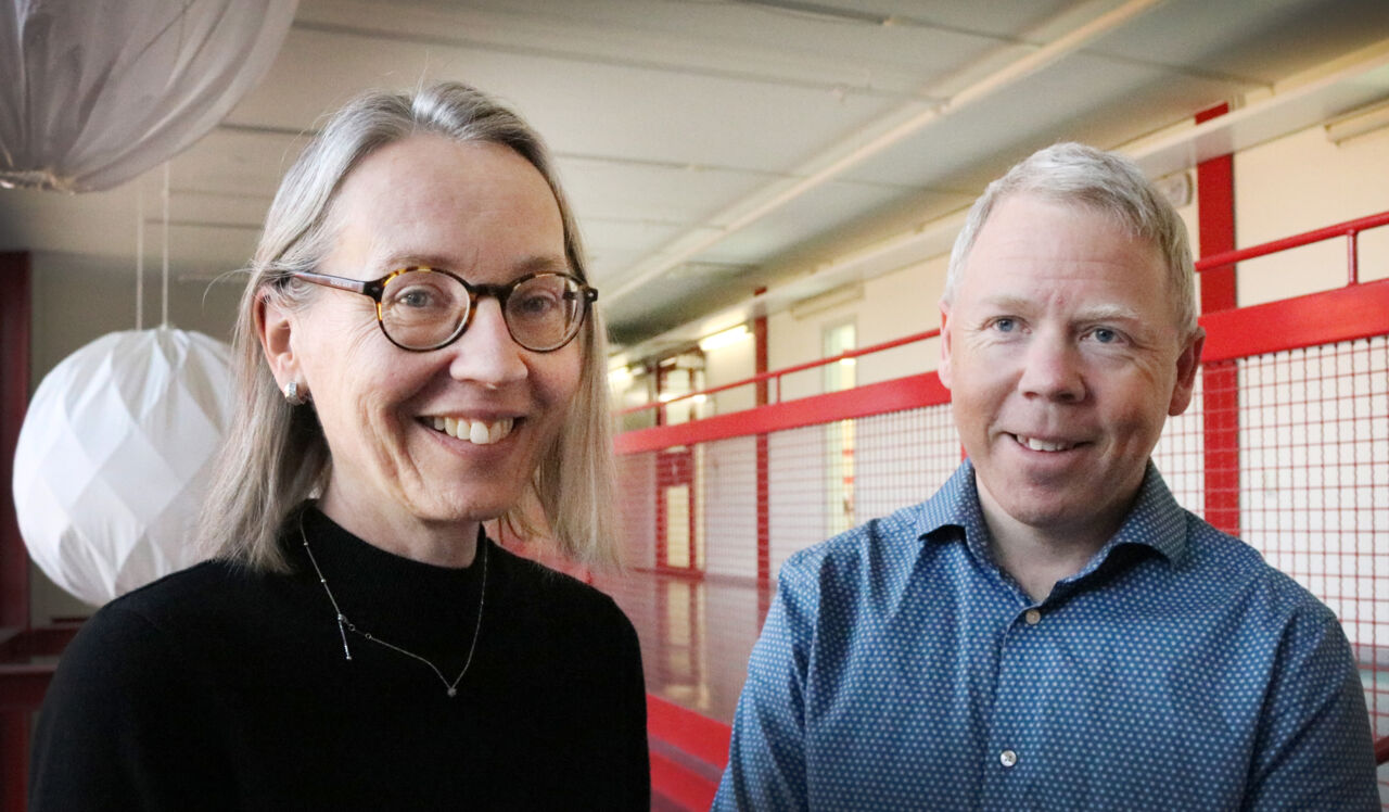 Manlig och kvinnlig forskare vid bokhylla.