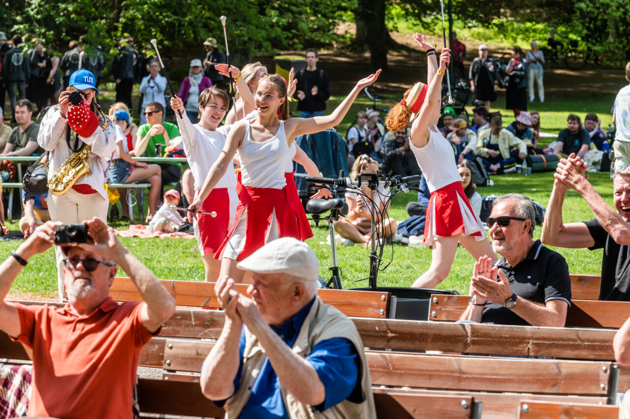 Audience claps, people play and dance.