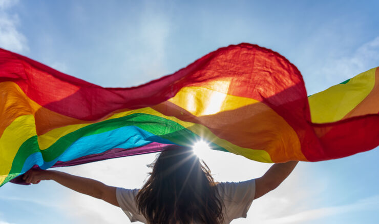 A woman waving a Pride flag. 