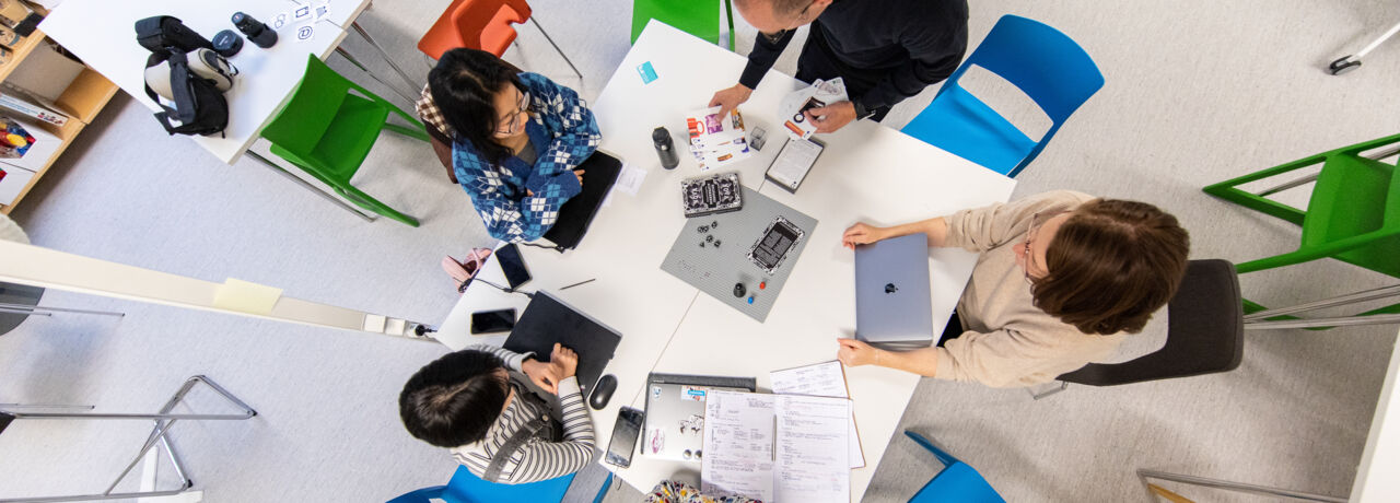 En grupp, sedd ovanifrån, arbetar vid ett bord