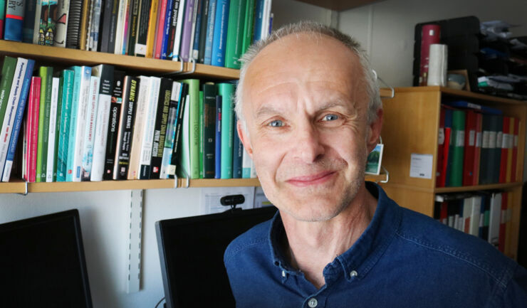 Male researcher by bookshelf