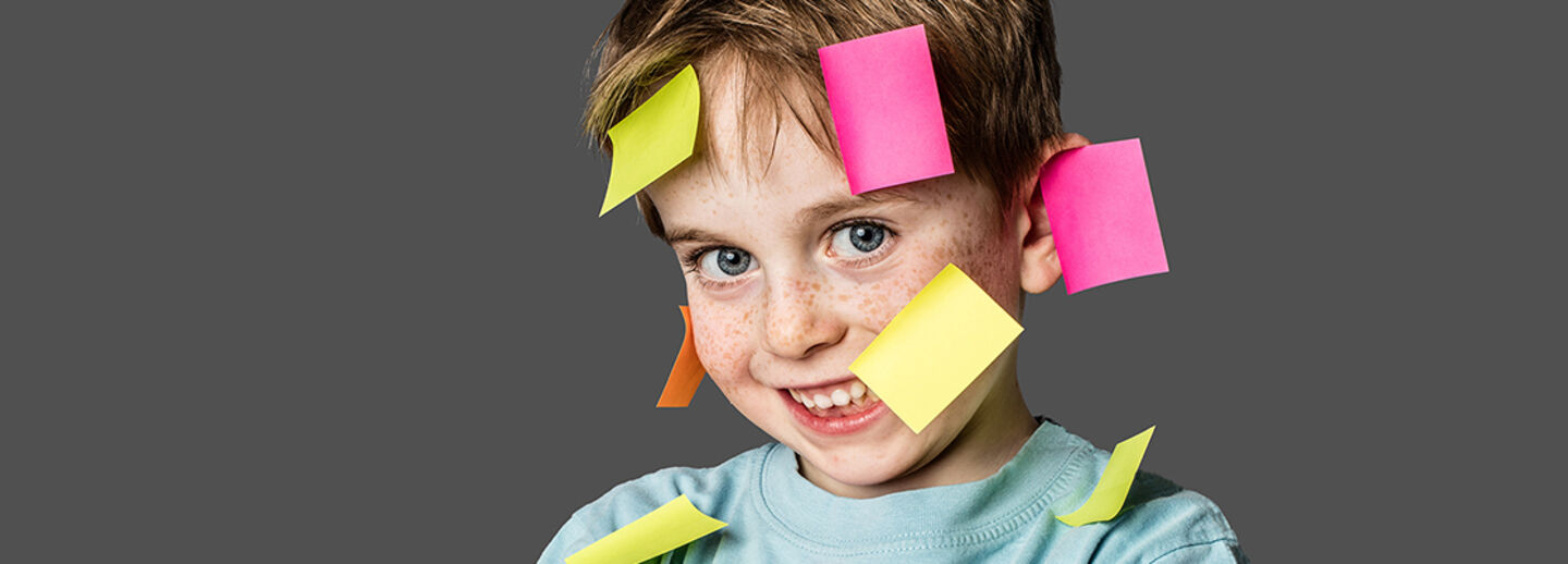 A boy with post-it notes. 
