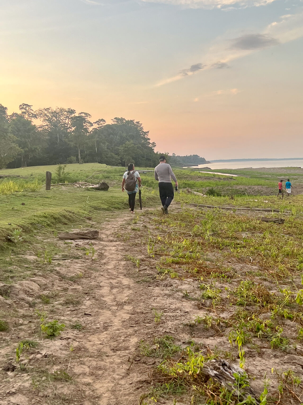Fyra människor på vandring ner mot floden.