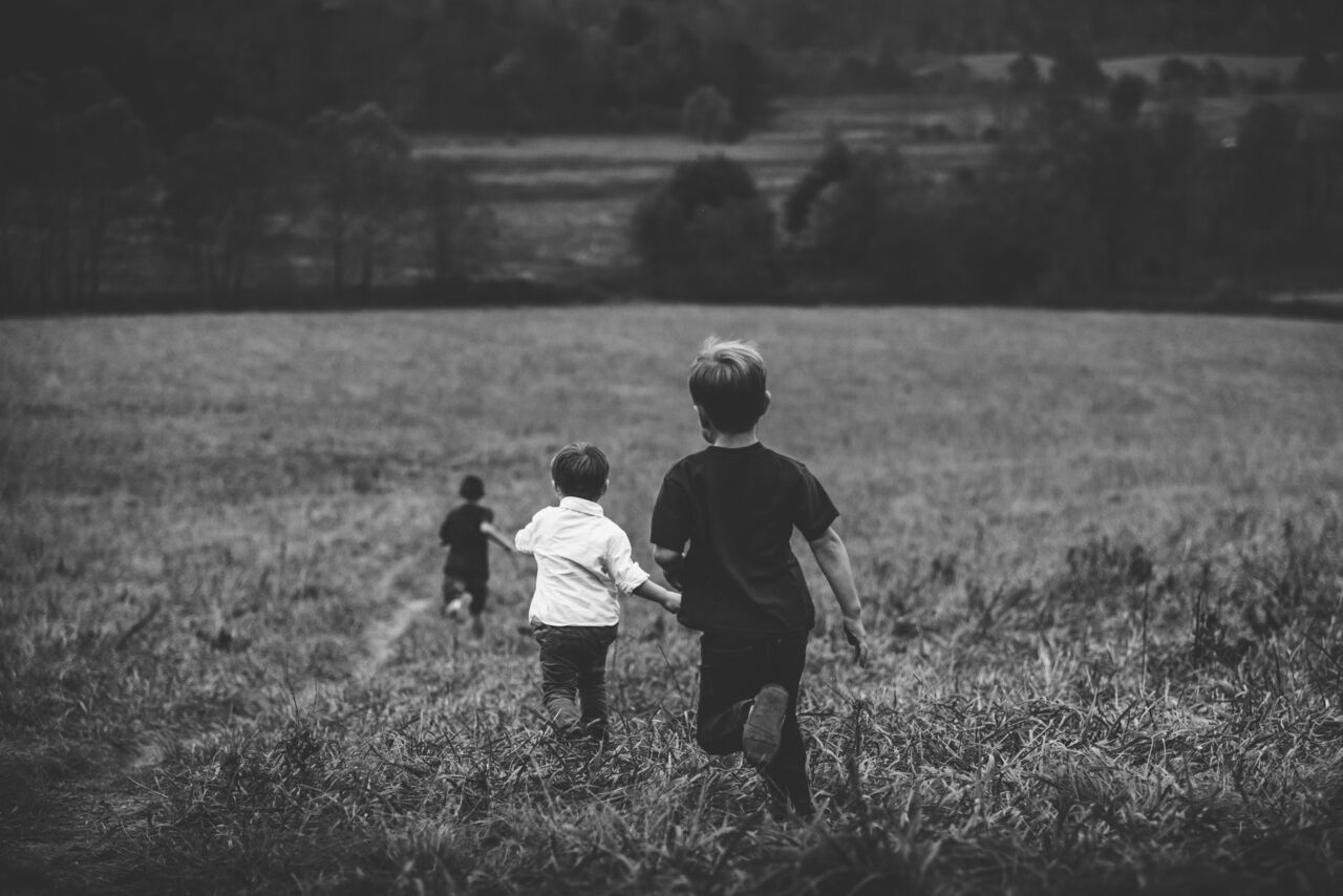 Barn springer på ett fält