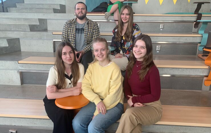 Students sitting in a stair indoors.