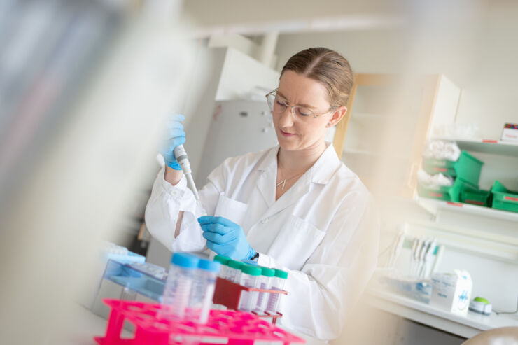 Young woman using a pipette in a laboratory.