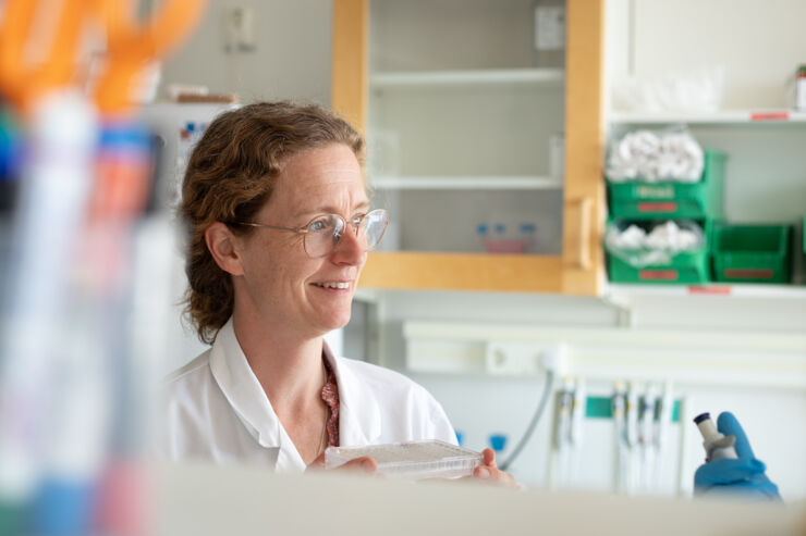 Kvinna i vit rock i laboratoriemiljö.