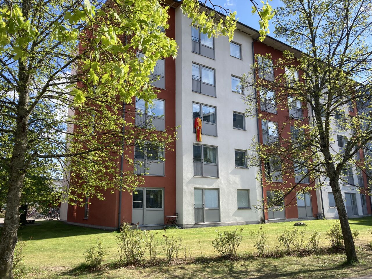 Studentoverall som hänger på vädring utanför ett fönster