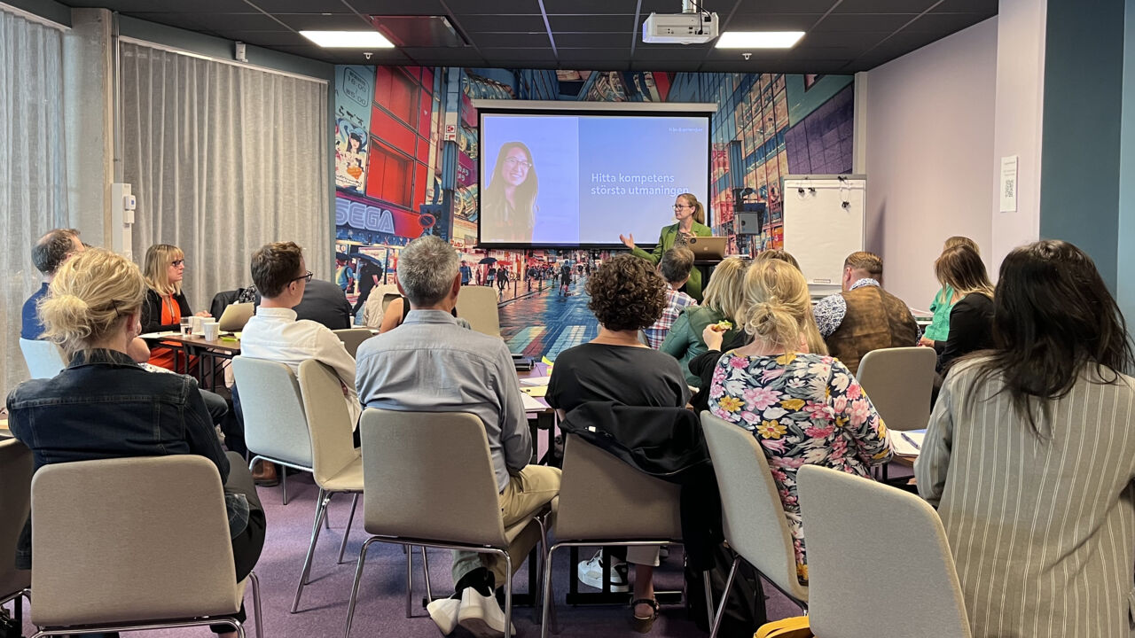 Group of people sitting ina room and listening to lecturer. 