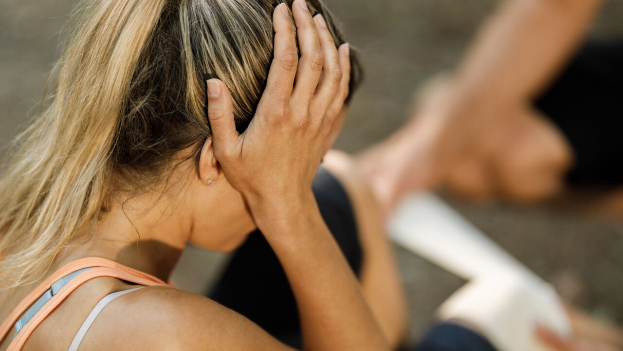 Idrottare håller händerna för huvudet och verkar skadad.