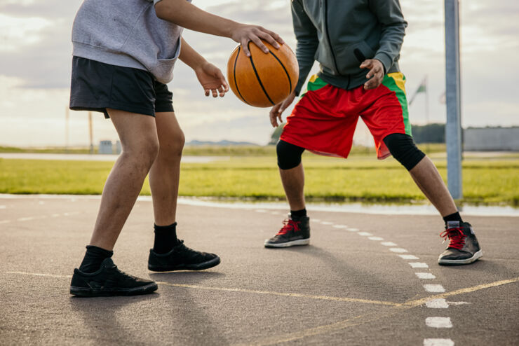 Ungdomar spelar basket.
