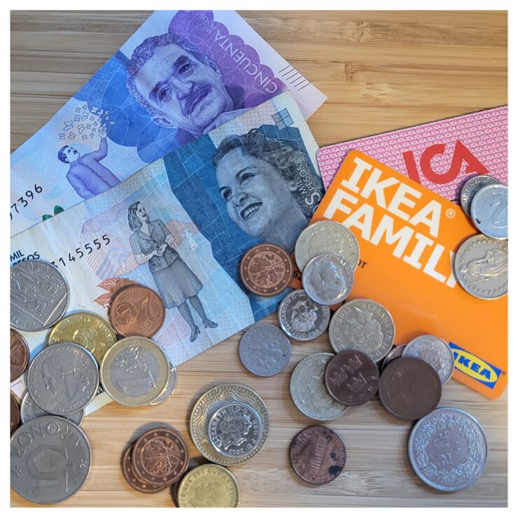 Money is laying on a table together with cards from IKEA and ICA.