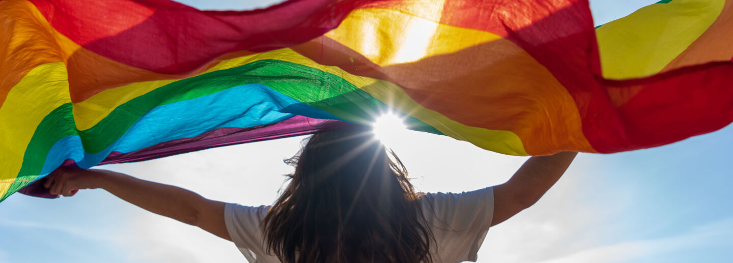 A woman waving a Pride flag. 