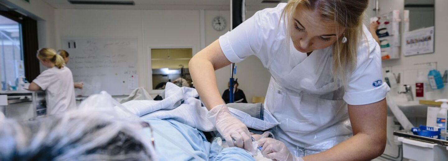 En sjuksköteskestudent tar ett prov på en patient.