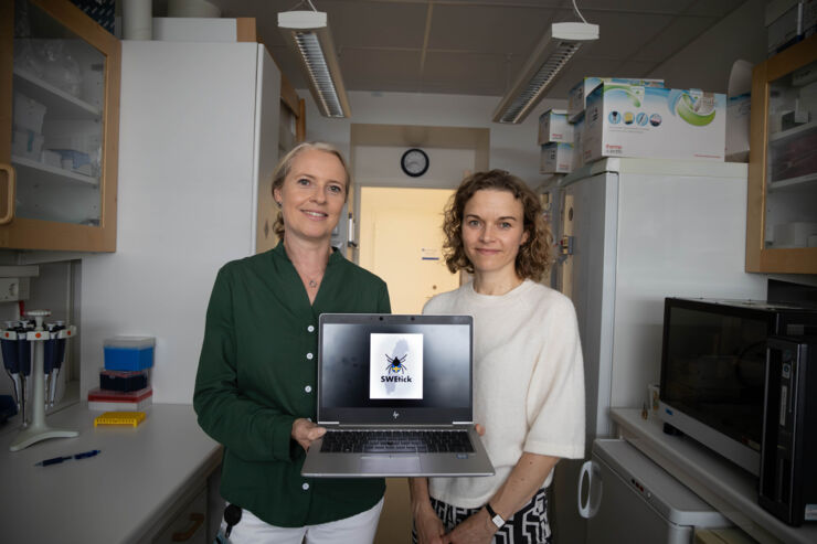 Bild på två kvinnor som håller en dator och visar upp logotypen för deras forskningsstude, SWEtick.