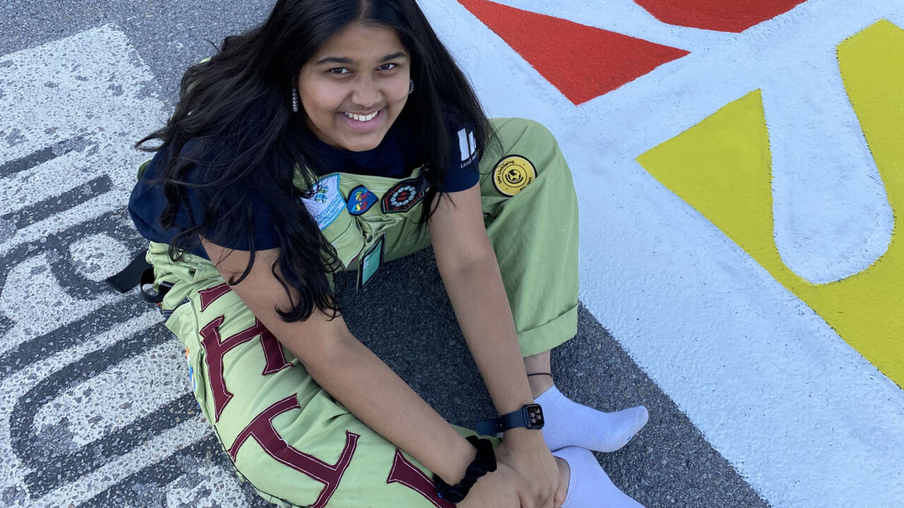 Student in overall sitting on the ground