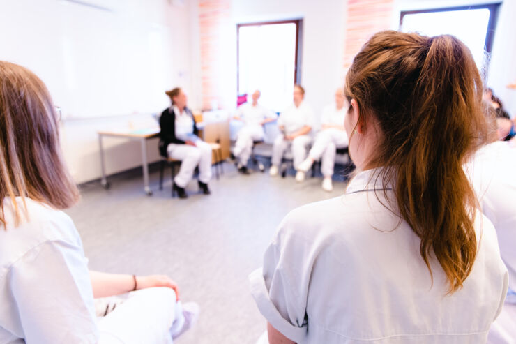 Läkarstudenter simulerar vårdsituationer och diskuterar under utbildningen.